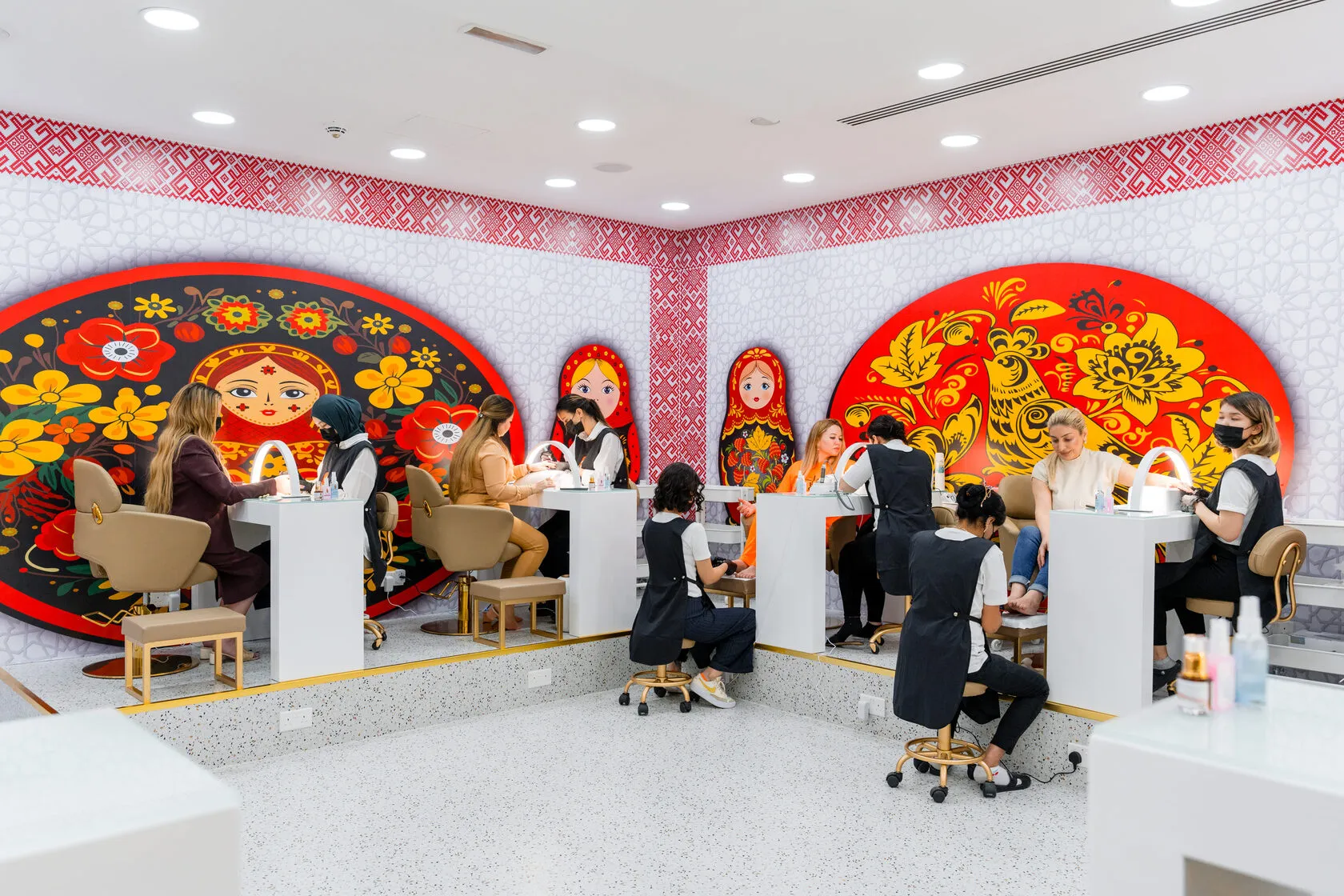 Matryoshka Beauty Salon interior — nail stations with traditional Russian Khokhloma murals